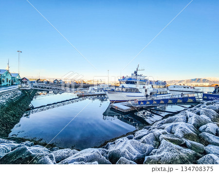 Passenger Boat Docked at Harbor with Calm Water and Mountains Passenger Boat Docked at Harbor with Calm Water and Mountains 134708375