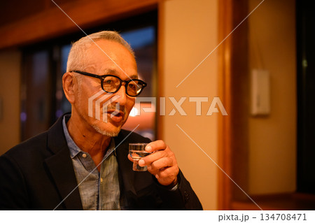 眼鏡の男性が日本酒を飲む 眼鏡の男性が日本酒を飲む 134708471