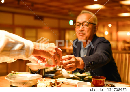 年配男性が日本酒を注がれる 134708473