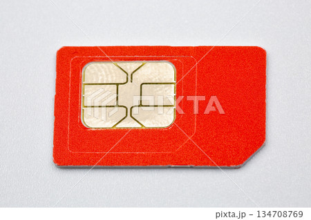 Orange SIM card with golden chip on white background closeup. 134708769