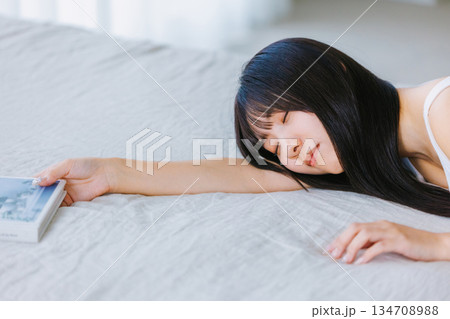 ベットで寝転ぶ若い女性 134708988