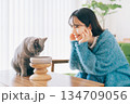 ご飯を食べる猫を見守る女性 134709056