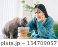 ご飯を食べる猫を見守る女性 134709057