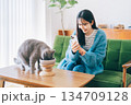 ごはんを食べるネコの写真を撮る女性　 134709128