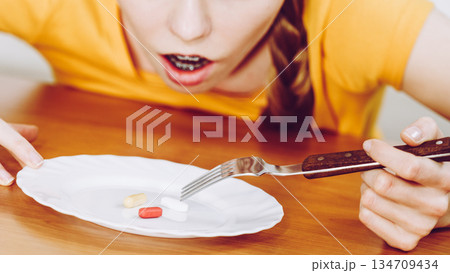 Shocked woman having pills on plate 134709434