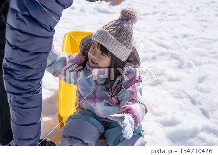 ソリで雪遊びする親子 134710426