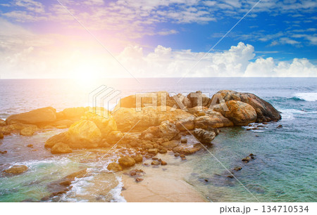 Scenic Coastal Landscape with Large Rocks and Golden Sunset Glow 134710534
