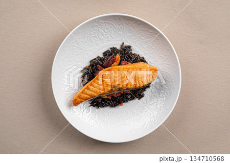 Grilled salmon with black rice and vegetables 134710568