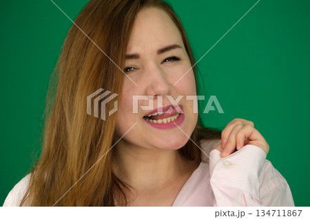 A young woman with stunning makeup smiles warmly while posing in a modern studio setting. A young woman with stunning makeup smiles warmly while posing in a modern studio setting. 134711867