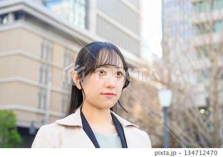 スーツを着てビル街で微笑む20代フレッシャーズのビジネスウーマン スーツを着てビル街で微笑む20代フレッシャーズのビジネスウーマン 134712470
