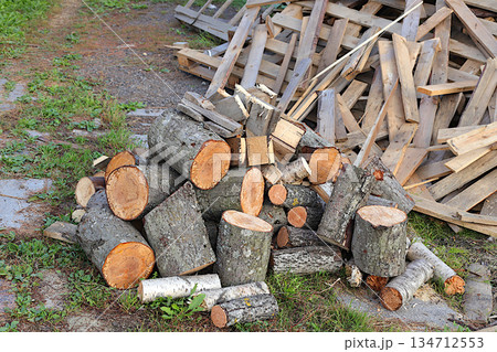 Chopped birch firewood in a pile outside. Preparing firewood for winter heating in a Russian village, an environmentally friendly fuel. Environmental protection concept, industriousness in the village Chopped birch firewood in a pile outside. Preparing firewood for winter heating in a Russian village, an environmentally friendly fuel. Environmental protection concept, industriousness in the village 134712553