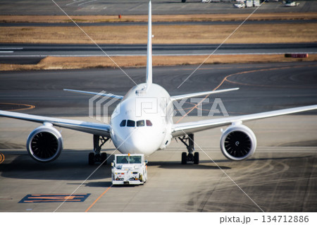 明るい日差しの下の真っ白な機体の大型飛行機 東京の羽田空港にて 明るい日差しの下の真っ白な機体の大型飛行機 東京の羽田空港にて 134712886