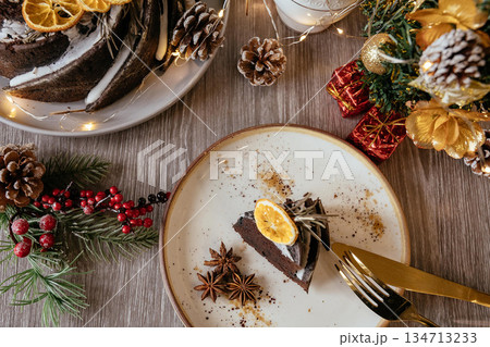 A slice of fruit pound cake, tea mug, Christmas tree branch on white wooden background, closeup view A slice of fruit pound cake, tea mug, Christmas tree branch on white wooden background, closeup view 134713233