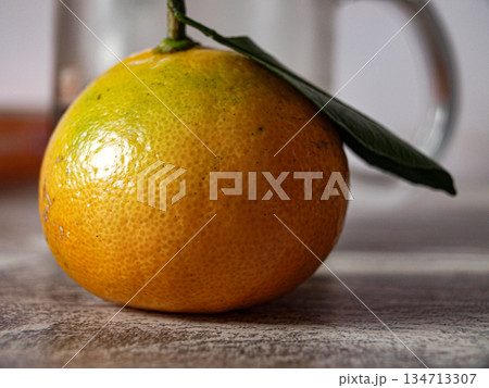 A tangerine with a leaf on the table. Breakfast. A tangerine with a leaf on the table. Breakfast. 134713307