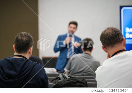 Business presentation at conference with speaker addressing attentive audience in a modern venue Business presentation at conference with speaker addressing attentive audience in a modern venue 134713494