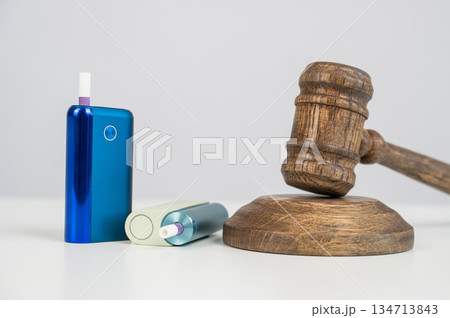 Judge's gavel and electronic cigarette. Smoking ban. Tobacco heating systems.  134713843