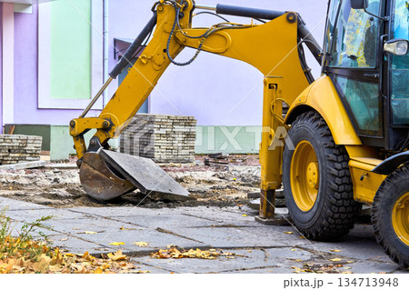 Remove.Excavator bulldozer loads old concrete slabs on road repair Remove.Excavator bulldozer loads old concrete slabs on road repair 134713948