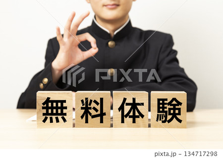 「無料体験」と書かれたブロックとOKサインをする男子学生 134717298