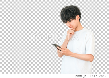 スマホを見ながら考える,検討する,悩む若いアジア人男性 スマホを見ながら考える,検討する,悩む若いアジア人男性 134717839