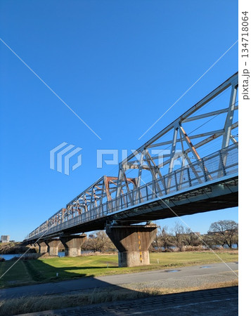 快晴の青空と続く鉄道橋 奥行きのあるトラス橋の風景（縦） 134718064
