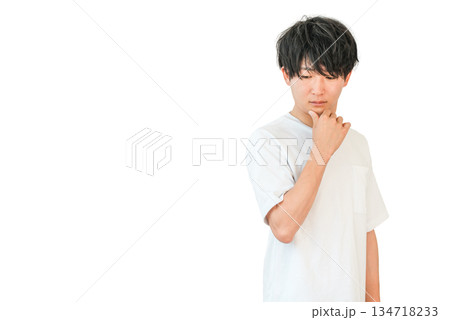 頬杖をつき俯く若いアジア人男性（考える,検討,悩む,後悔,不満,不信感） 134718233