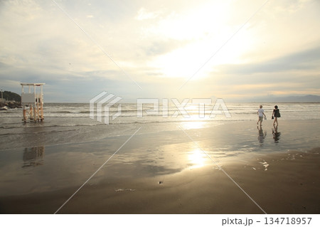 夕暮れの海を散歩する女性二人 夕暮れの海を散歩する女性二人 134718957