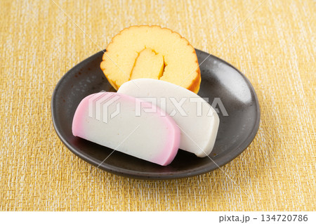 お皿に載せた伊達巻と紅白かまぼこ 134720786