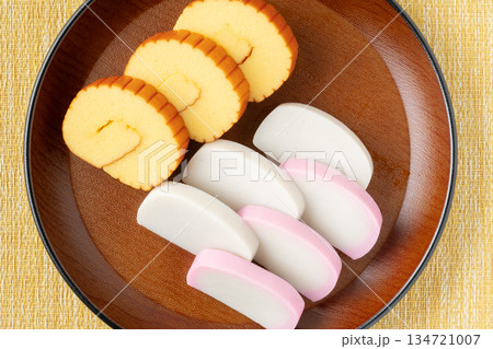 美しく盛りつけた伊達巻と紅白かまぼこのクローズアップ 美しく盛りつけた伊達巻と紅白かまぼこのクローズアップ 134721007