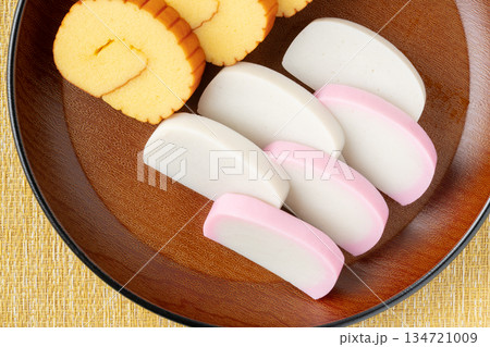 美しく盛りつけた伊達巻と紅白かまぼこのクローズアップ 美しく盛りつけた伊達巻と紅白かまぼこのクローズアップ 134721009