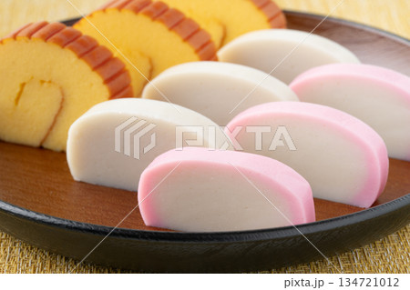 美しく盛りつけた伊達巻と紅白かまぼこのクローズアップ 134721012