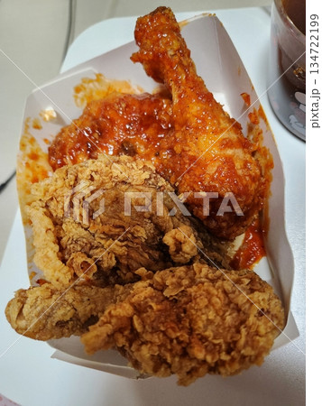 Crispy Korean fried chicken, perfectly glazed with a sweet and spicy sauce. Ideal for food photography and menus, showcasing the irresistible crunch and flavor of this beloved dish. 134722199