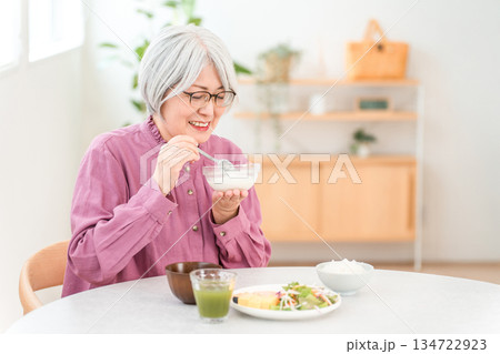 朝食にヨーグルト・乳製品を食べるグレイヘアーのシニア女性（ビフィズス菌・乳酸菌・乳製品・腸活） 134722923