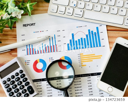 ビジネス資料と虫眼鏡、スマホ、PC、電卓 134723659