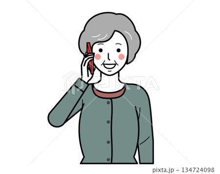 正面向き。スマホで電話をするカーディガンを着た高齢女性。 134724098