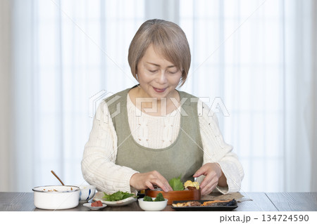 キッチンで弁当を作るシニア女性 134724590