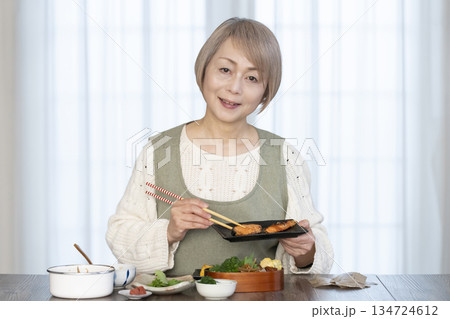 キッチンで弁当を作るシニア女性 134724612