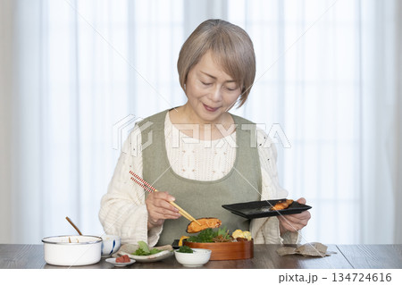 キッチンで弁当を作るシニア女性 134724616