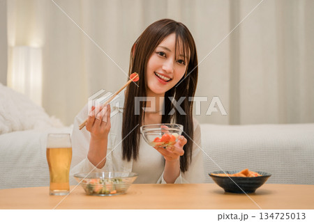 家の寝室でおつまみを食べながら晩酌する若いアジア人女性(ビール,家飲み,飲酒習慣) 家の寝室でおつまみを食べながら晩酌する若いアジア人女性(ビール,家飲み,飲酒習慣) 134725013
