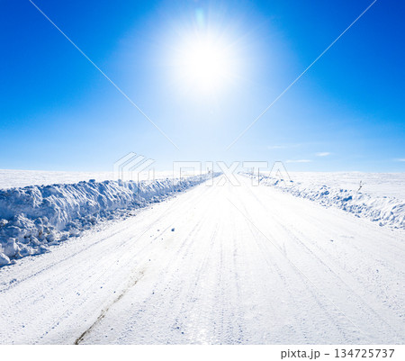 冬の北海道美瑛町の青空と太陽と圧雪アイスバーン道路の風景 134725737