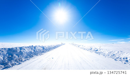 冬の北海道美瑛町の青空と太陽と圧雪アイスバーン道路の風景 134725741