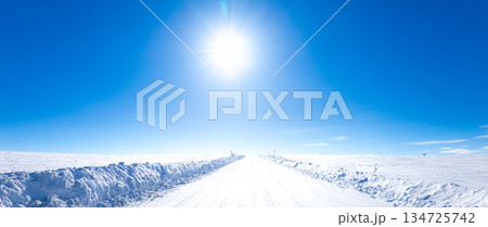 冬の北海道美瑛町の青空と太陽と圧雪アイスバーン道路の風景 134725742