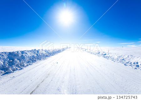 冬の北海道美瑛町の青空と太陽と圧雪アイスバーン道路の風景 134725743