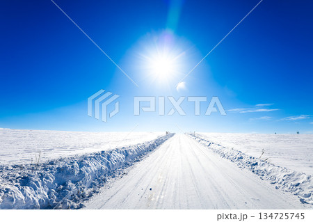 冬の北海道美瑛町の青空と太陽と圧雪アイスバーン道路の風景 134725745