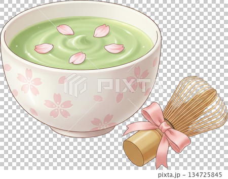 Green matcha tea in a decorative bowl with pink petals and a bamboo whisk 134725845