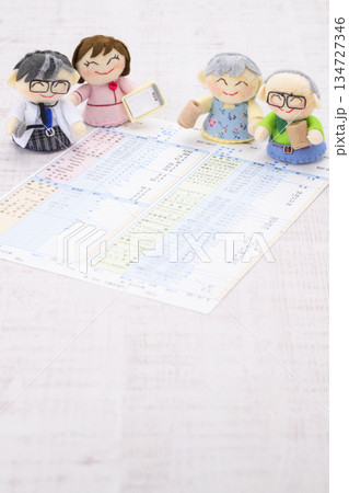 医師、看護師、おじいちゃん、おばあちゃんの人形と健康診断の結果の用紙 134727346