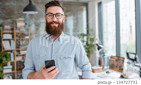 Modern Entrepreneur Showcasing App Design in Creative Office Setting 134727731