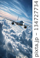 Commercial Airplane Banking Over Clouds in Deep Blue Sky with Sunlit Tones 134727734
