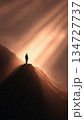 Inspirational Figure Standing in Sun Rays on Mountain Peak 134727737