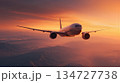 Airplane Cruising at Twilight with Gradient Orange Sky and Cinematic Lighting 134727738