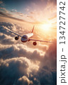 Airplane Soaring Above Clouds with Sunlight Flare in Cinematic View 134727742